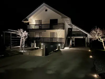 a house lit up at night with lights at Cozy stay near Bled in Radovljica