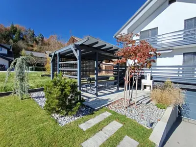 a garden with a picnic shelter in front of a house at Cozy stay near Bled in Radovljica
