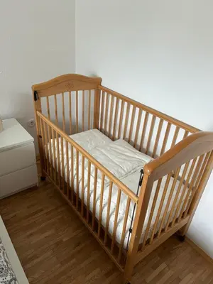 a wooden crib in a room with wooden floors at Cozy stay near Bled in Radovljica