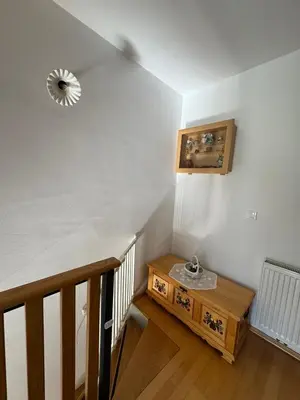 a room with a staircase with a table and a mirror at Apartment MANCA-HOLIN in Bohinj