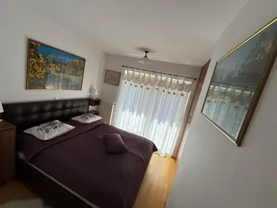 a bedroom with a bed and a large window at Apartment MANCA-HOLIN in Bohinj