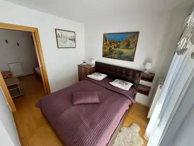 a bedroom with a bed with a purple blanket at Apartment MANCA-HOLIN in Bohinj