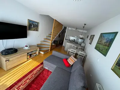 a living room with a couch and a flat screen tv at Apartment MANCA-HOLIN in Bohinj