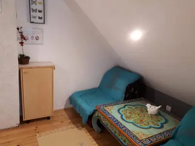 a small room with a blue chair and a table at Cottage Stela Bohinj in Bohinj