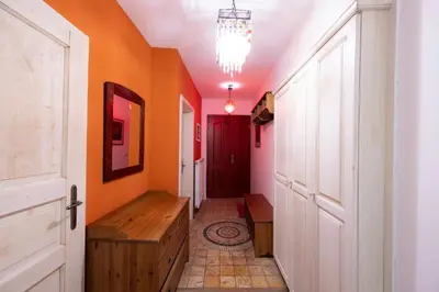 a hallway with orange walls and a wooden bench at Hiša Linhart Apartment in Radovljica
