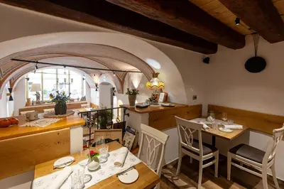 a restaurant with tables and chairs in a room at Hiša Linhart Apartment in Radovljica