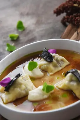a bowl of soup with dumplings in it at Hiša Linhart Apartment in Radovljica