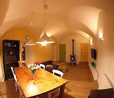 a living room with a table and a living room with a fireplace at Hiša Linhart Apartment in Radovljica