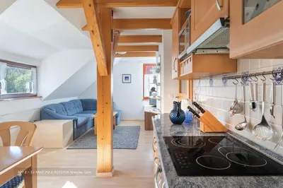 a kitchen with a stove top oven next to a living room at Apartmaji Potepuh in Kranjska Gora