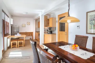 a kitchen and dining room with a wooden table and chairs at Apartmaji Potepuh in Kranjska Gora