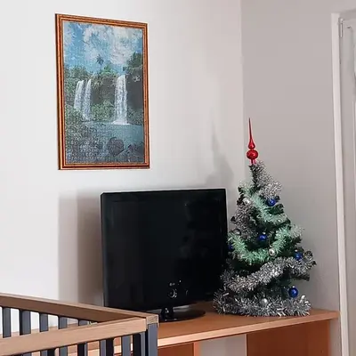a christmas tree sitting on a table next to a television at Apartma pri Milki in Cerkno
