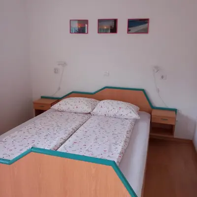 a bed in a small room with two night stands at Apartma pri Milki in Cerkno
