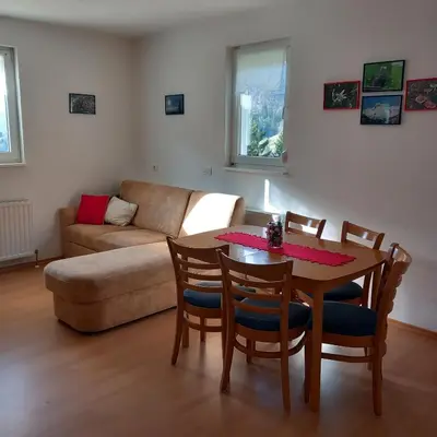 a living room with a table and chairs and a couch at Apartma pri Milki in Cerkno