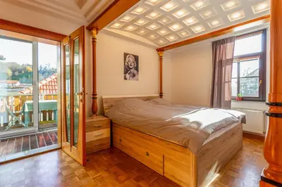 a bedroom with a large bed and a balcony at Apartma Apolon I in Krško