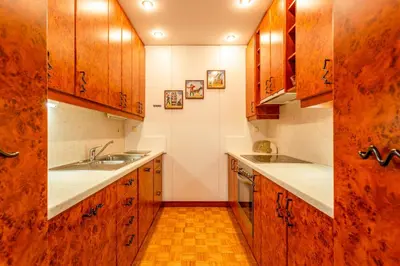 a kitchen with wooden cabinets and a sink at Apartma Apolon I in Krško