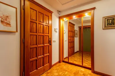 a hallway with wooden doors and a mirror at Apartma Apolon I in Krško
