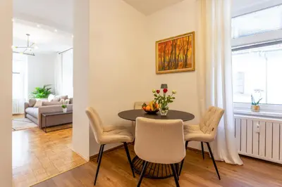 a dining room with a table and chairs and a couch at Apartma Apolon II in Krško