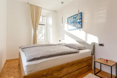 a bedroom with a large bed with a window at Apartma Apolon II in Krško