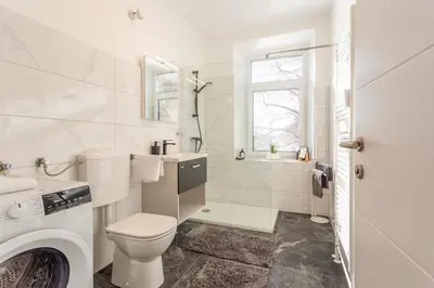 a white bathroom with a toilet and a sink at Apartma Apolon II in Krško