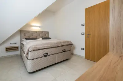 a bedroom with a large bed and a wooden cabinet at Apartma pri Hrvatu in Bohinj
