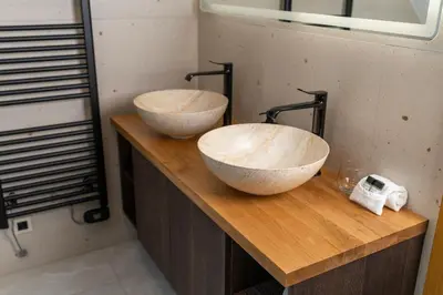 two sinks on a wooden counter in a bathroom at Apartma pri Hrvatu in Bohinj