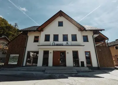 a white building with a brown roof at Apartma pri Hrvatu in Bohinj