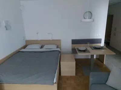 a small bedroom with a bed and a table at Bohinj Jeglič C17 in Bohinj