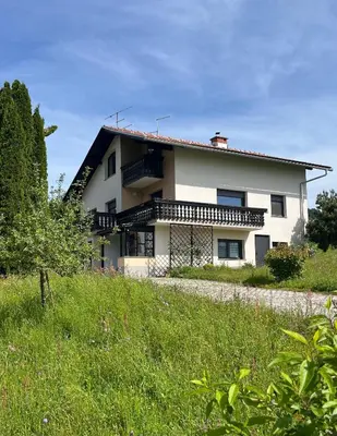 a white house with a black roof at Apartment River in Vitanje
