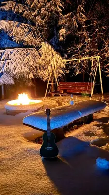 a surfboard sitting on the beach with a fire in the background at Apartment River in Vitanje