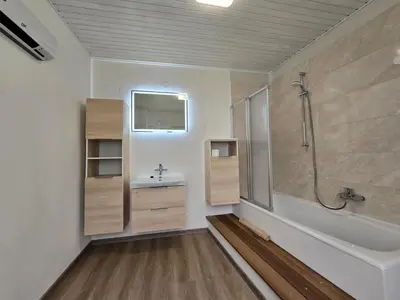 a bathroom with a tub and a sink and a shower at Apartments Denis in Tolmin