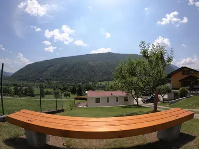 a wooden bench sitting in front of a house at Apartments Denis in Tolmin