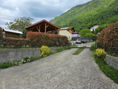 a gravel road leading to a house with a fence at Apartments Denis in Tolmin