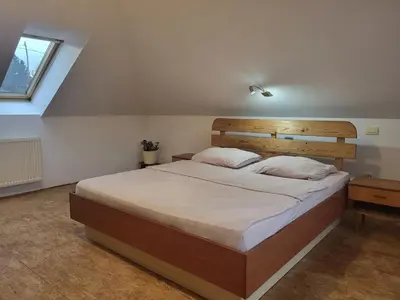 a bedroom with a large bed with a wooden headboard at Kmečka Vila in Višnja Gora