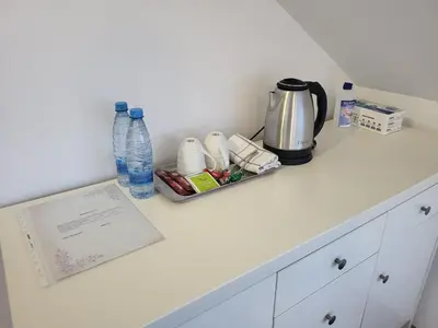 a counter with a coffee maker and bottles of water at Kmečka Vila in Višnja Gora