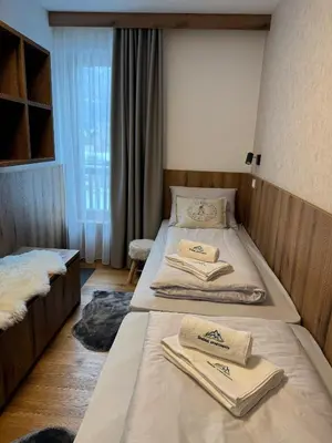 a bedroom with two beds with towels on them at Steblaj apartments Park in Kranjska Gora