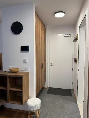 a hallway with a door and a clock on the wall at Steblaj apartments Park in Kranjska Gora