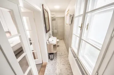 a small bathroom with a sink and a mirror at OH Apartments & Rooms in Ljubljana