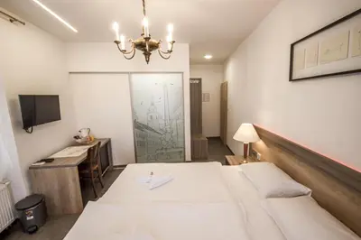 a bedroom with a bed and a desk and a television at OH Apartments & Rooms in Ljubljana