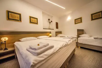 two beds in a room with towels on them at OH Apartments & Rooms in Ljubljana