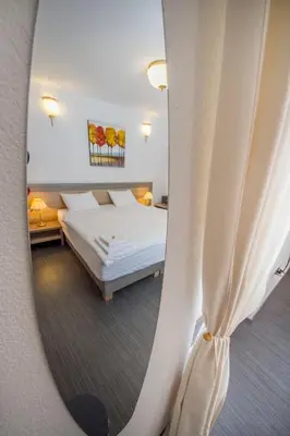a bedroom with a bed and a mirror at OH Apartments & Rooms in Ljubljana