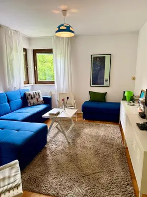 a living room with a blue couch and a table at Lotti's Apartment in Kranjska Gora