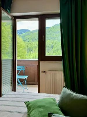 a bedroom with a bed and a large window at Lotti's Apartment in Kranjska Gora