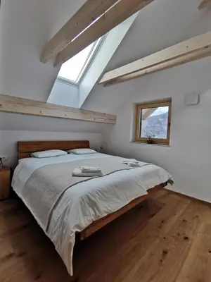 a bedroom with a large bed and a window at Vila Perunika in Bohinj