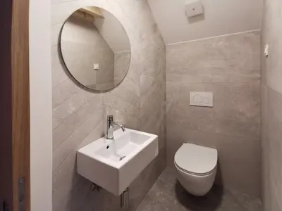 a bathroom with a sink and a toilet and a mirror at Vila Perunika in Bohinj
