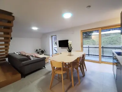 a living room with a table and a couch at Vila Perunika in Bohinj