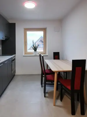 a kitchen with a table and chairs and a window at Vila Perunika in Bohinj