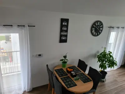 a dining room table with chairs and a clock on the wall at Maya-K apartment near city center in Ljubljana