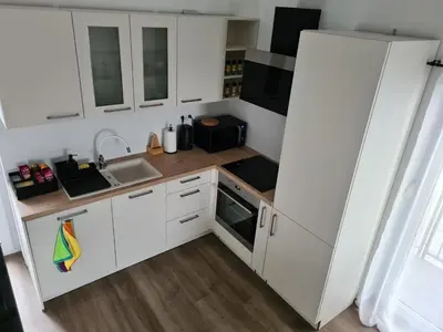 a small kitchen with white cabinets and a sink at Maya-K apartment near city center in Ljubljana