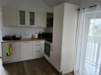 a kitchen with white cabinets and a sink and a window at Maya-K apartment near city center in Ljubljana