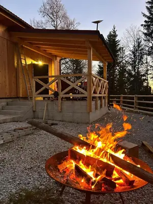 a fire pit in front of a cabin at Gorska koča Krvavec in Cerklje na Gorenjskem